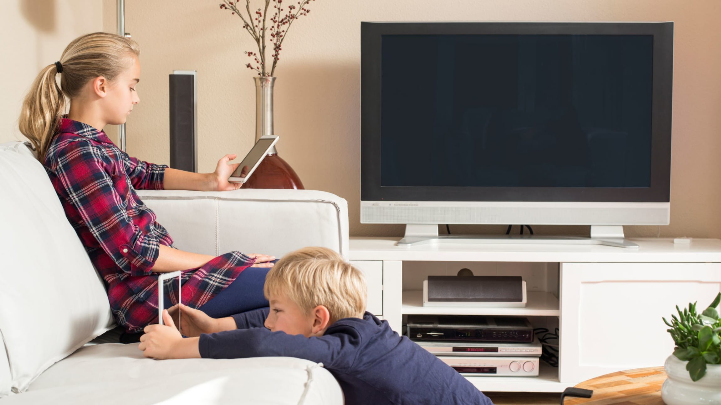 Kinder mit Tablet auf dem Sofa